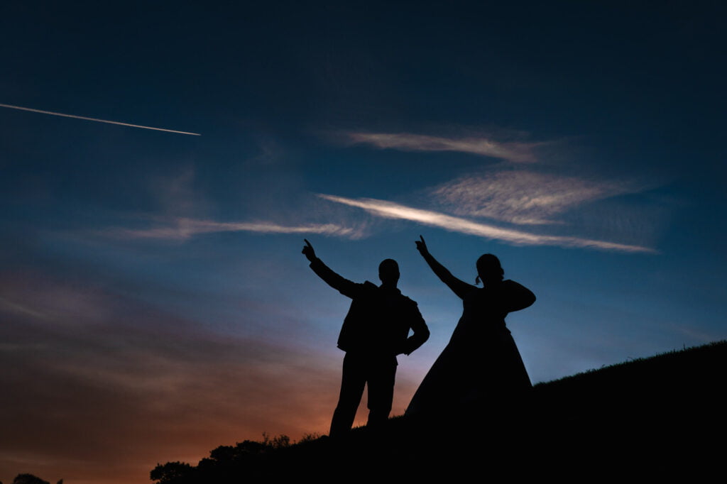 nottingham couple in silhouette with their arms pointing to the sky